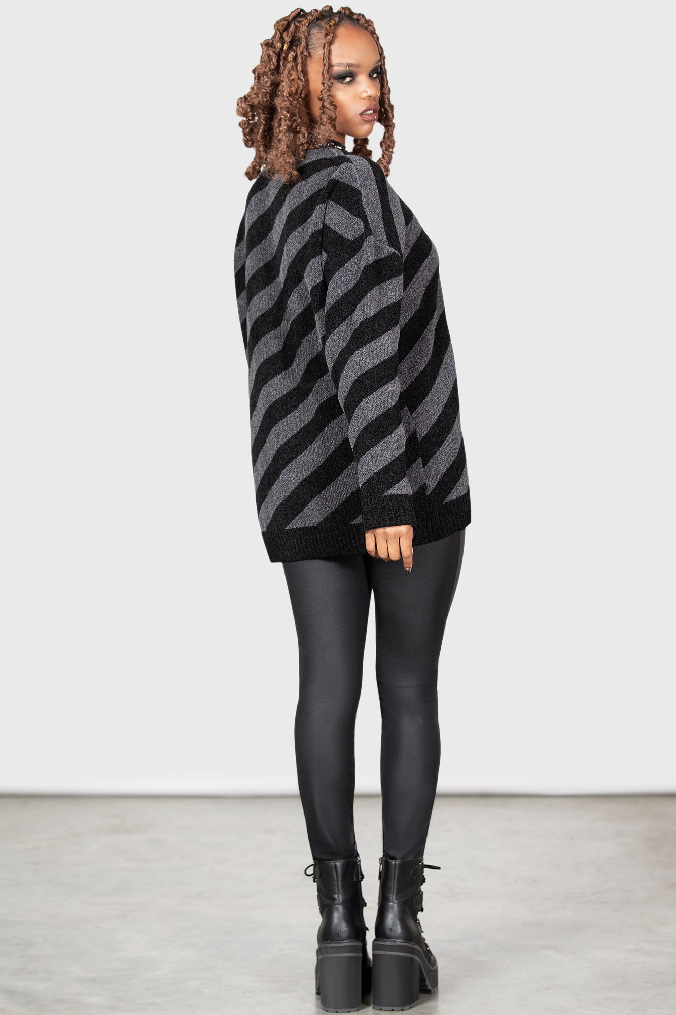 Woman in oversized sweater and black leggings standing in a dark room on  Craiyon